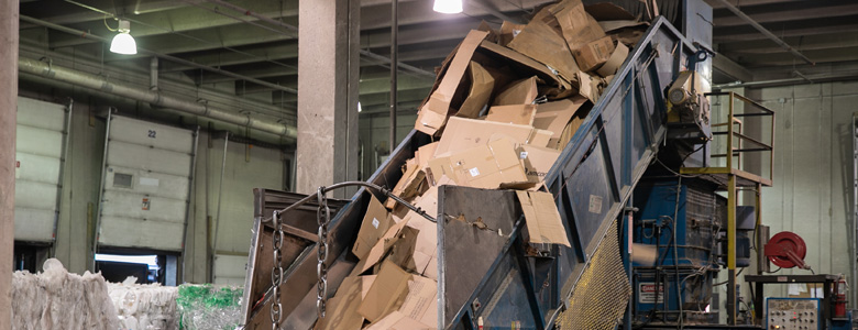 A conveyor belt moving cardboard to be recycled.