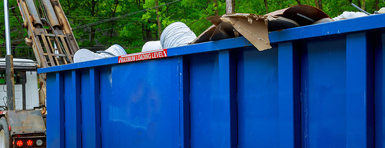 A full dumpster getting picked up.