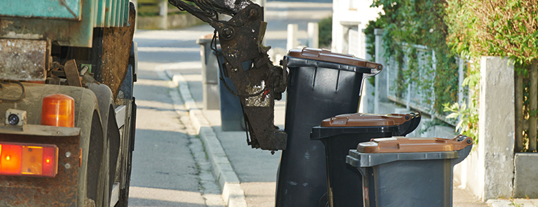 An LJP waste collection truck picking up trash cans.